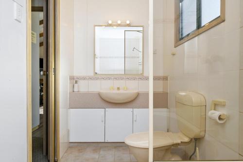 a bathroom with a toilet and a sink at Howlong Caravan Park in Howlong
