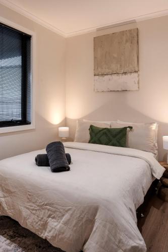 a bedroom with a large white bed with two pillows at Sixty - House 1 in Currie
