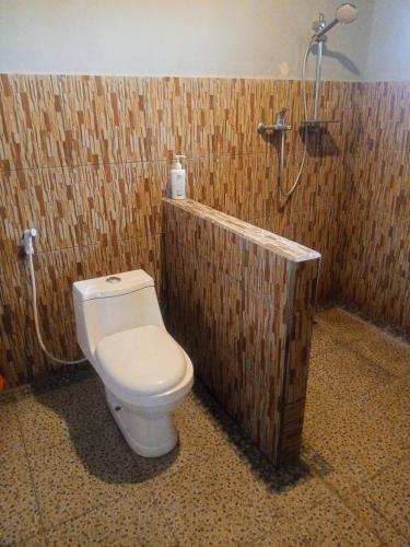 a bathroom with a toilet and a shower at Linkgreen Homestay Lombok in Tetebatu