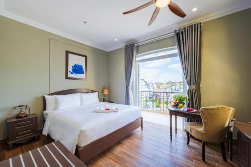 a bedroom with a bed and a window with a balcony at Mallorie Hotel Dalat in Xuan An