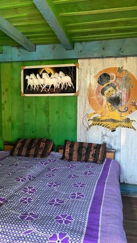 ein Bett in einem Zimmer mit einer grünen Wand in der Unterkunft DADU'S Cafe in Sainj