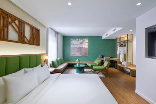 a hotel room with a bed and a living room at NiK Hotel Nguyen Trai in Ho Chi Minh City