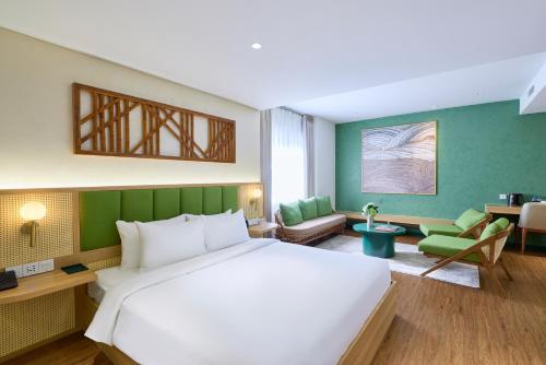 a bedroom with a large white bed and green walls at NiK Hotel Nguyen Trai in Ho Chi Minh City