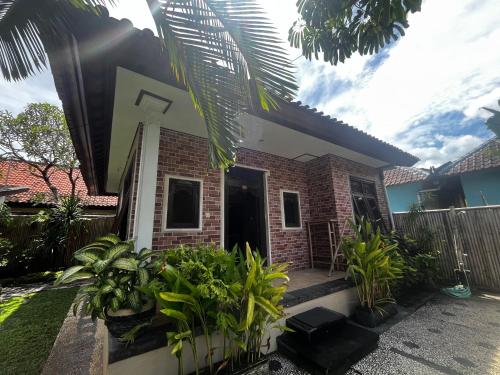 a house with a bunch of plants in front of it at Tiga Naga Villa in Denpasar
