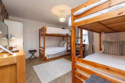 a room with two bunk beds and a desk at Waterside Equestrian Lodge in Durham