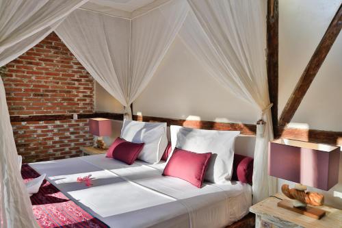 a bedroom with a bed with red and white pillows at Villas SAMALAMA Gili Trawangan in Gili Trawangan