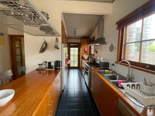 a large kitchen with wooden counters and a sink at Cedar Hill Retreat in Venus Bay