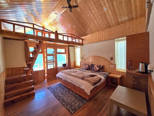 a bedroom with a large bed in a wooden house at River View Sunrise Cottages Tirthan Valley in Kulu