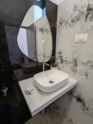 a bathroom with a sink and a large mirror at Om Coast Gokarna in Gokarna