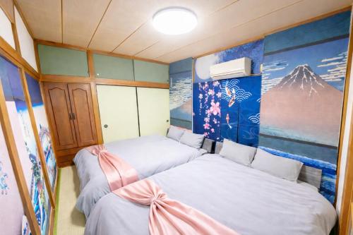 a small room with two beds in it at 1200IN&OUT 4people 35m2 2Queenbed! 1sofabed! Exclusive house Shinjuku 18 minutes Shibuya 22 minutesIkebukuro 11 minutes in Tokyo