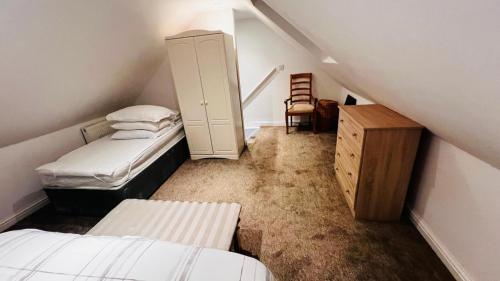 a attic room with two beds and a cabinet at Waterside annexx in Durham