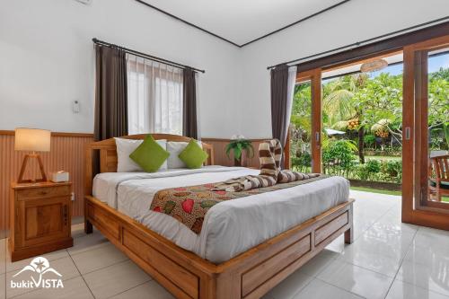 a bedroom with a bed and a large window at The Bingin Green View by Bukit Vista in Uluwatu
