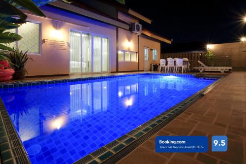 a swimming pool in a house at night at Thepprasit Cosy in Jomtien Beach