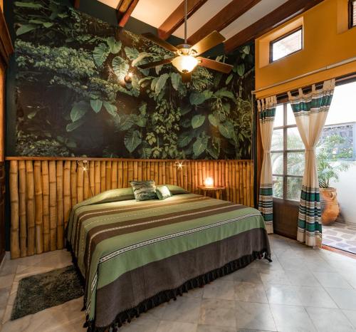 a bedroom with a bed and a large painting on the wall at Villa de Dos Armadillos in Santa Maria Huatulco
