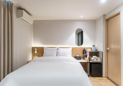 a bedroom with a large white bed and a desk at Incheon Juan Chungchoon Hotel in Incheon