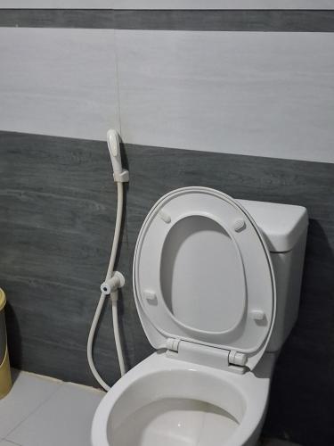 a white toilet with a hose attached to it at Beach cabin uppuveli in Trincomalee