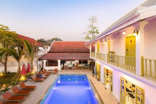 una casa con piscina al lado de un edificio en White Elephant Hostel, en Luang Prabang