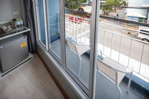 a white chair sitting in front of a window at The Moon Hostel Huahin in Hua Hin