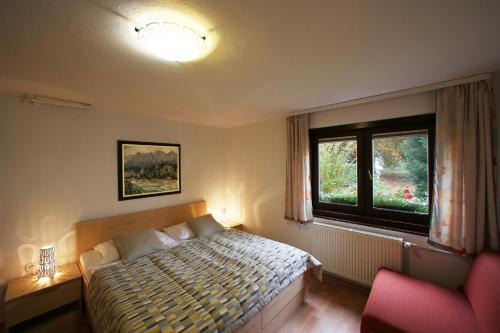 - une chambre avec un lit, une fenêtre et une chaise dans l'établissement Apartment Bernik II, à Kranjska Gora