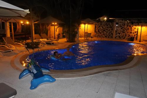 two people in a swimming pool at night at Godiva Villa Phu Quoc in Phu Quoc