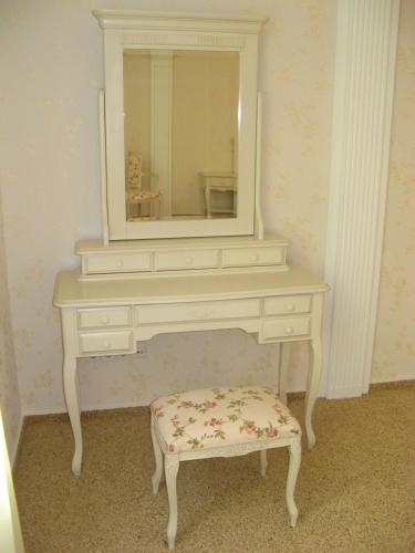 a white dressing table with a mirror and a stool at Hotel Complex Zelenyi Gai in Kopachuvka