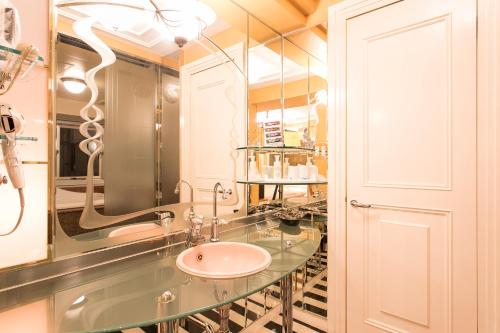 ein Bad mit einem Waschbecken und einem Spiegel in der Unterkunft HOTEL PAL Otsuka -Adult Only- in Tokio