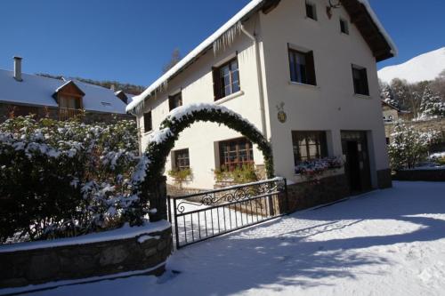 a building with a gate in the snow at Le Gite 5 mn de Luchon - Jardin garage et parking in Benque-Dessous-et-Dessus