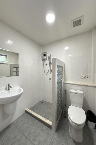 a bathroom with a shower and a toilet and a sink at Be Leaf Resort SHA in Thalang
