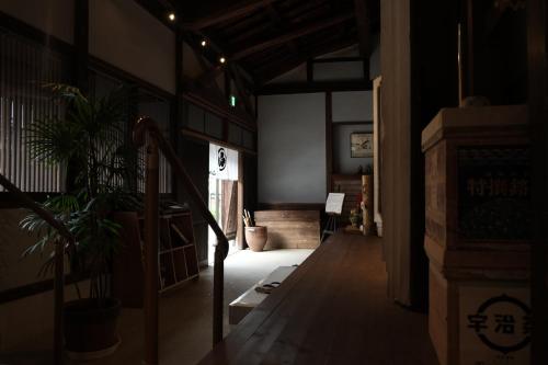 una habitación con un pasillo con plantas y una escalera en Etchu Yatsuo Base OYATSU en Toyama