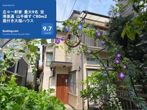 a sign in front of a house with flowers at 2025年グッドレビュー賞受賞 広々一軒家 最大9名 空港直通 山手線すぐ80m2庭付き大福ハウス in Tokyo