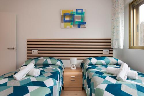 a room with two beds and a window at El rincón de las Delicias in Zaragoza