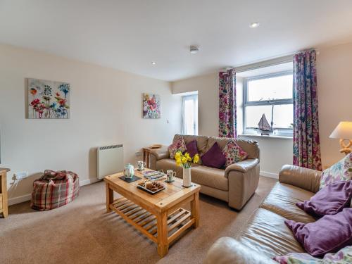 a living room with two couches and a coffee table at Bwthyn Hudol - Uk46711 in Pwllheli
