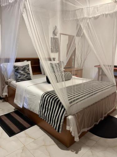 a bedroom with a bed with mosquito nets at The Dream Homestay in Ella