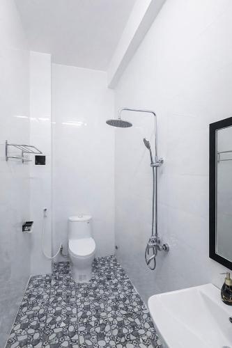 a white bathroom with a toilet and a sink at Tâm An Hotel in Nhơn Trạch
