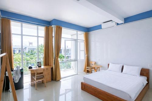 a bedroom with a bed and a large window at Tâm An Hotel in Nhơn Trạch
