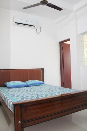 a bed in a room with a ceiling fan at Anand Lodge in Thiruchendur