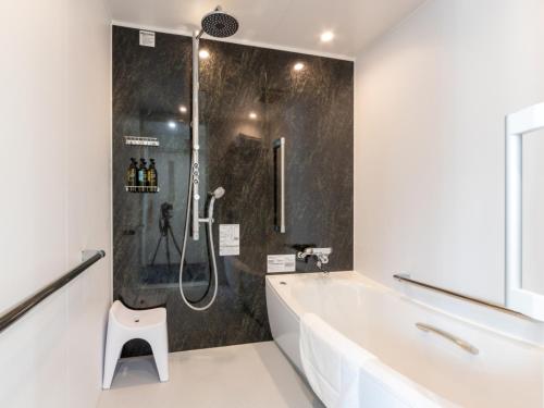 a bathroom with a shower and a tub and a sink at Kurayoshi City Hotel in Kurayoshi