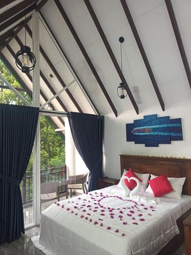 a bedroom with a bed with red pillows at Ranthilaka Villas in Kandy