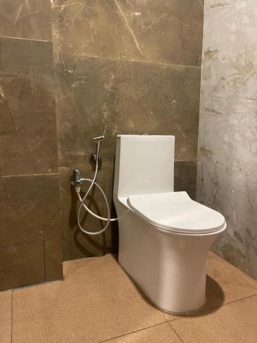 a white toilet in a bathroom with a shower at HOTEL SSK PRIME in Vijayawāda