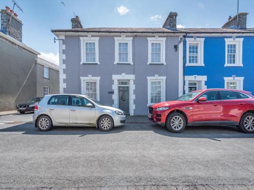 two cars parked in a parking lot in front of a house at Glendower in Aberaeron