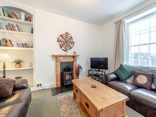 a living room with a couch and a fireplace at Glendower in Aberaeron
