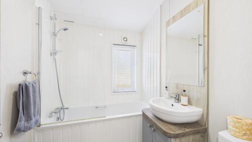 a white bathroom with a sink and a mirror at Rowan a welcoming countryside lodge in Ryde
