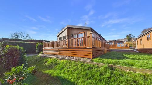 a large wooden cabin in the middle of a yard at Rowan a welcoming countryside lodge in Ryde