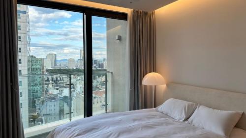 a bedroom with a bed and a large window at Caelum Black Gangnam Luxury Residence in Seoul