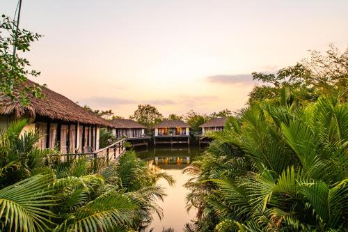a resort with a bridge and trees and water at Good Time Relax Resort in Kampot