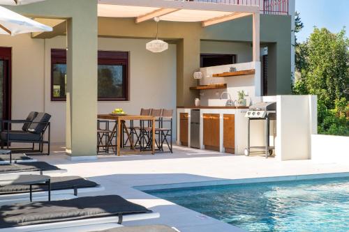 a patio with a swimming pool and a house at Cicada Villa in Koskinou