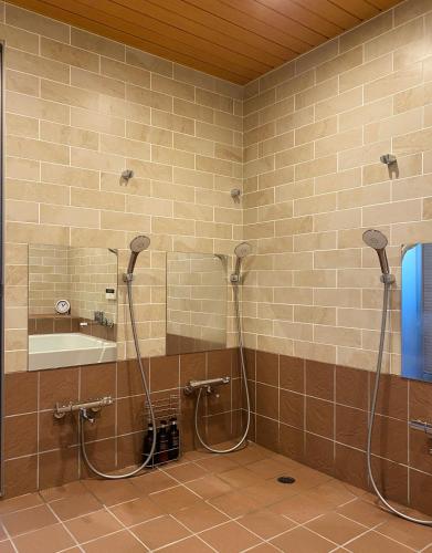 a bathroom with two shower heads and a sink at 春日旅館-Kasuga Ryokan- in Nabari