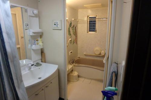 a bathroom with a tub and a sink and a toilet at KazenoKi in Kichijōji