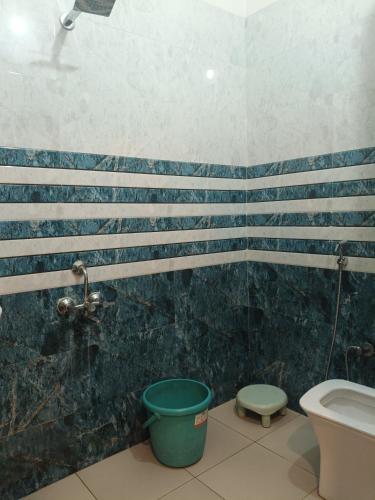 a bathroom with a toilet and a bucket at The Shree Ganesh Hotel in Khātu