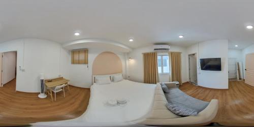 a large white room with a couch and a tv at Marshmallow House in Sathani Lak Si
